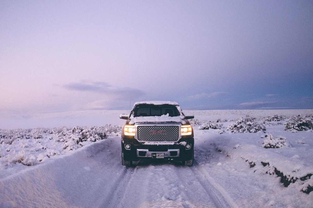 GMC Sierra Denali pickup truck driving through a snowy field