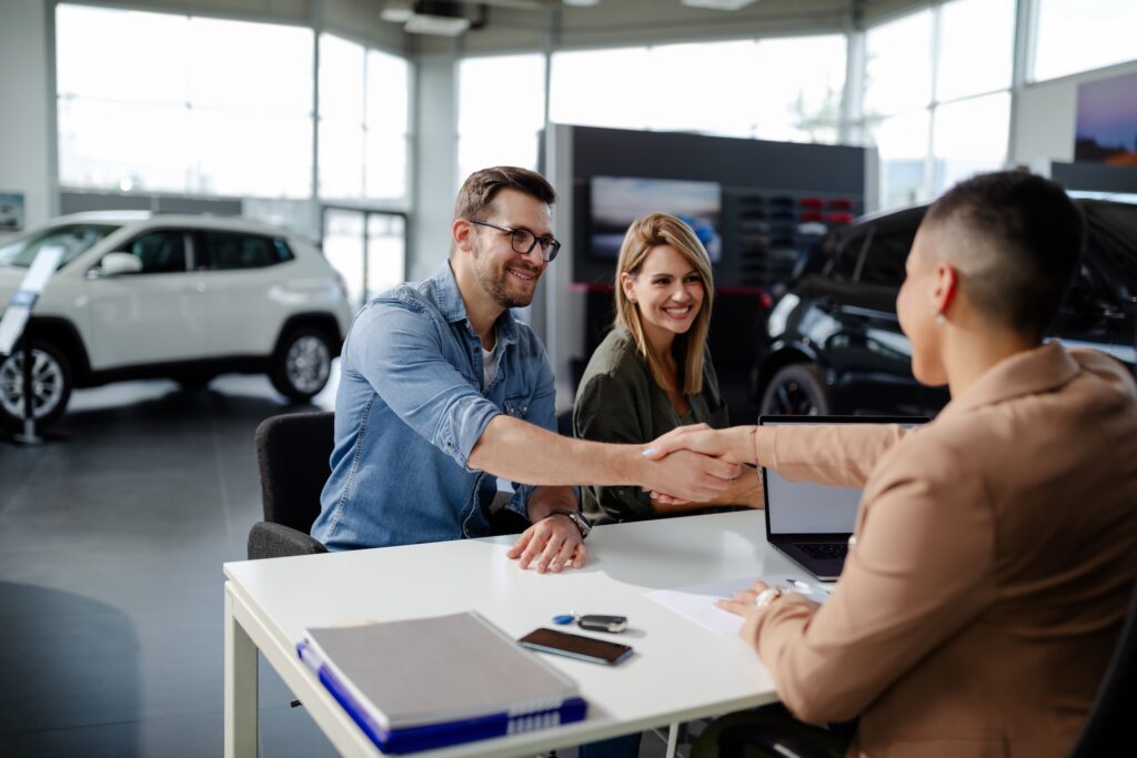 Car loan paperwork and keys on a dealership desk