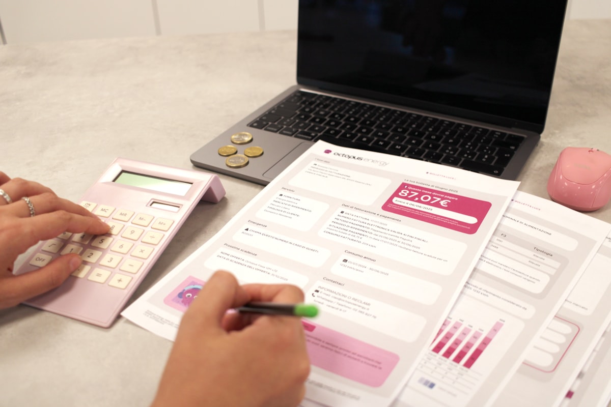 Person reviewing financial paperwork with a calculator