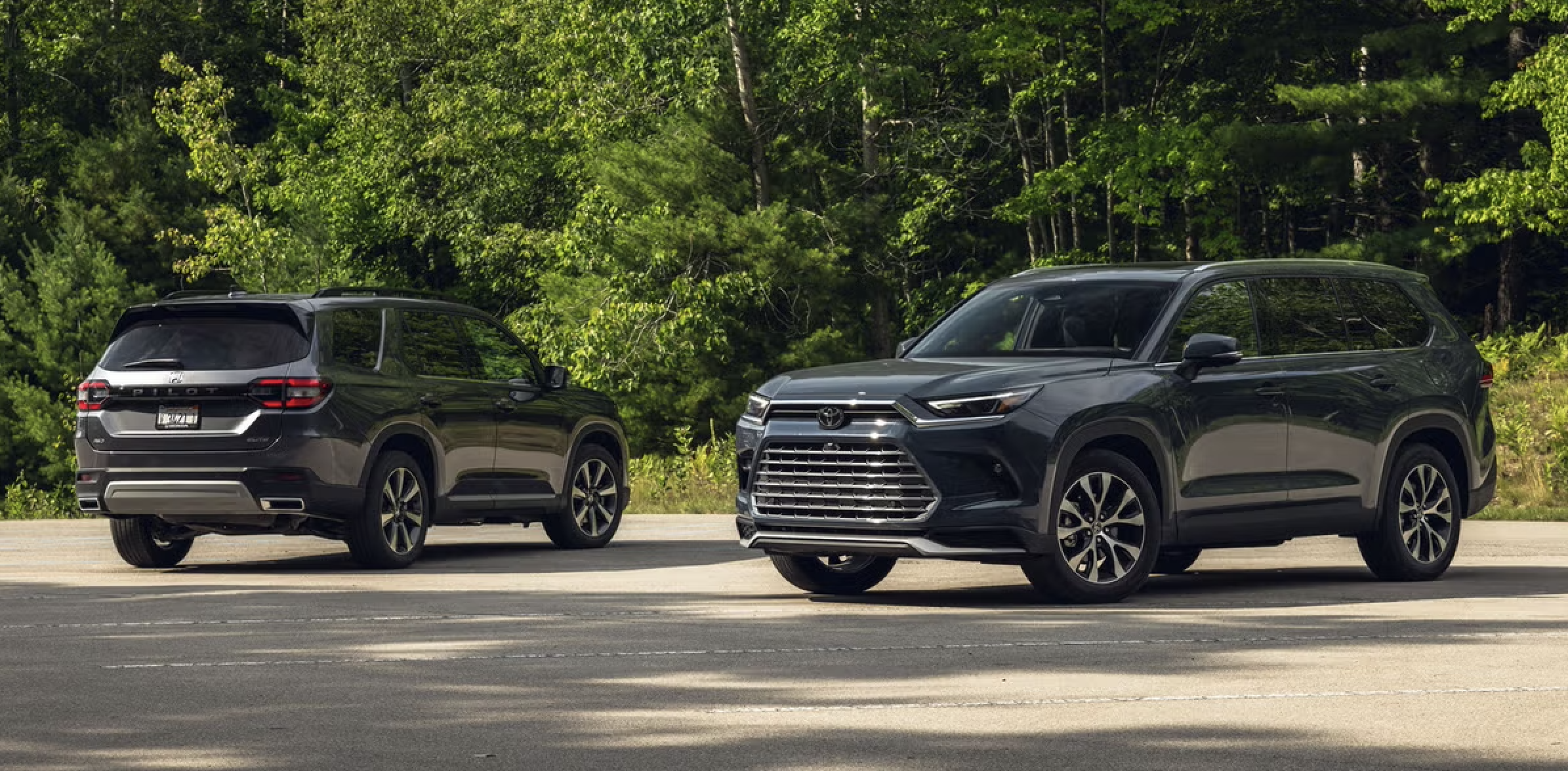 2026 Honda Pilot and Toyota Highlander parked side by side at a suburban trailhead