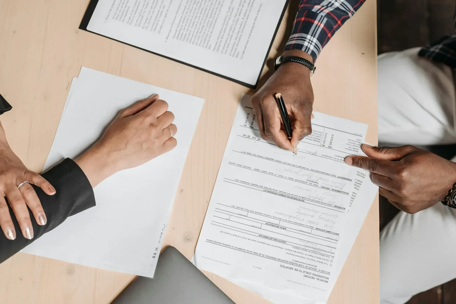 Buyer signing car financing paperwork at a dealership