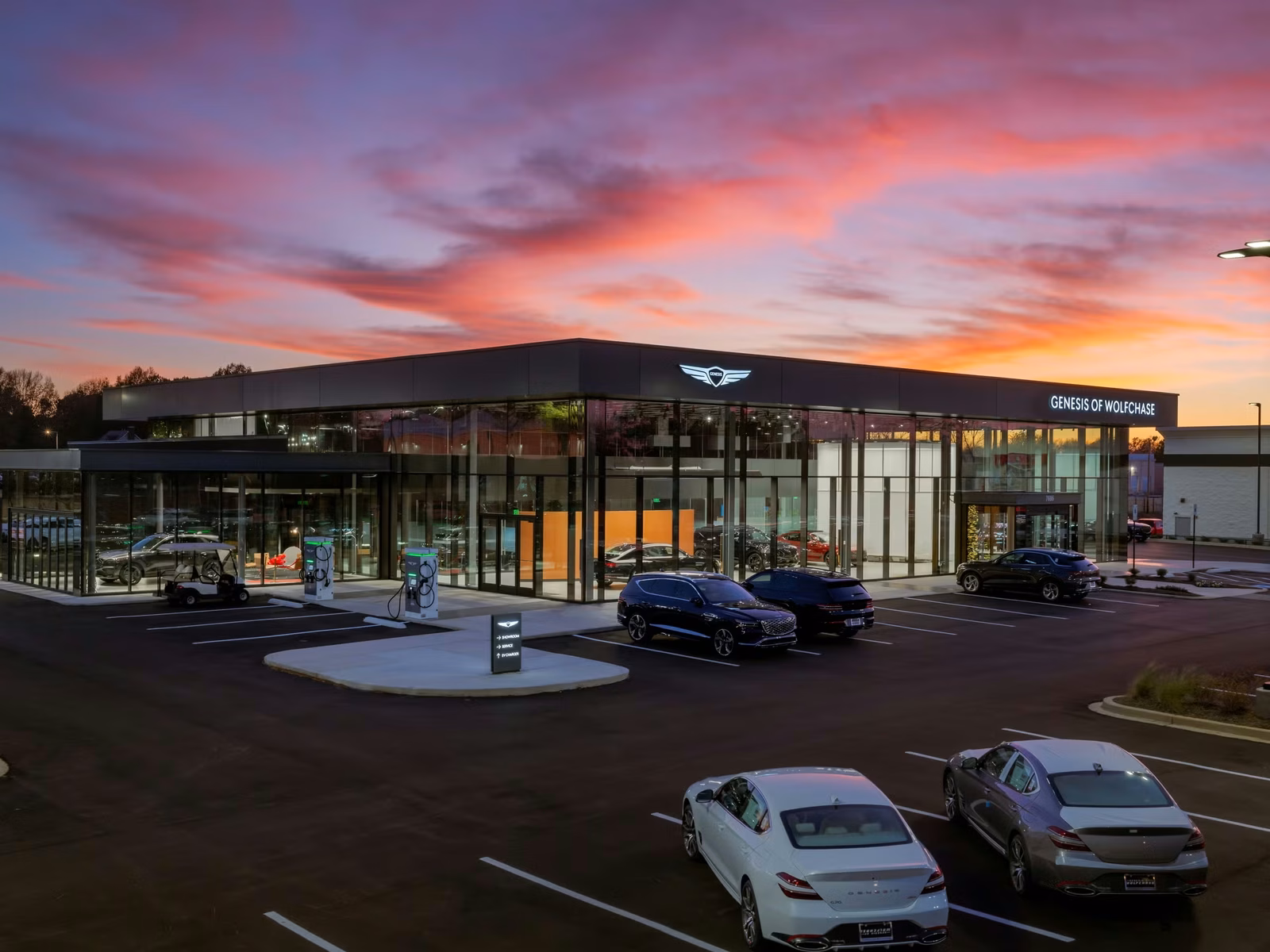 Genesis dealership exterior with luxury sedans and SUVs in the showroom