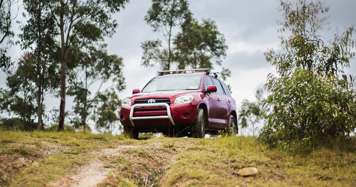 A red Toyota RAV4 on a trail