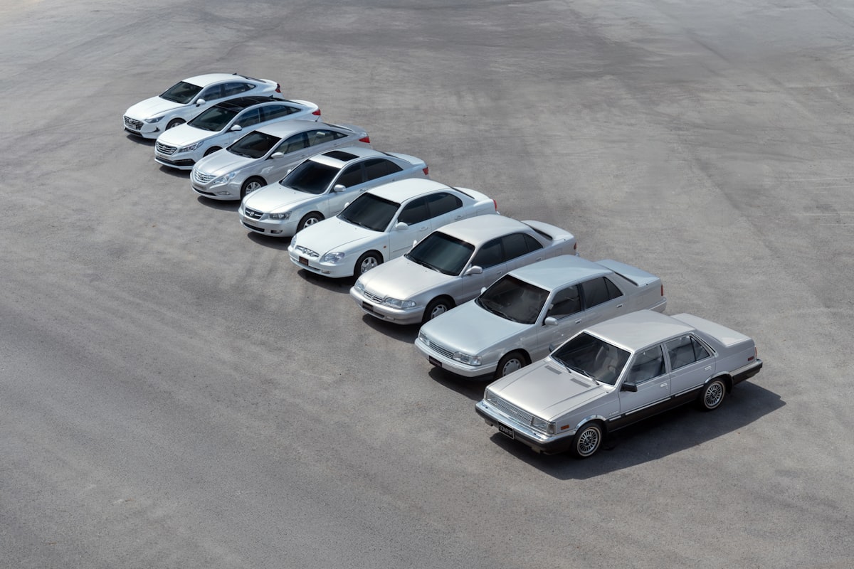 Row of sedans at a car dealership under sunny skies