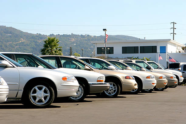 Used cars displayed on an independent dealership lot on a spring day